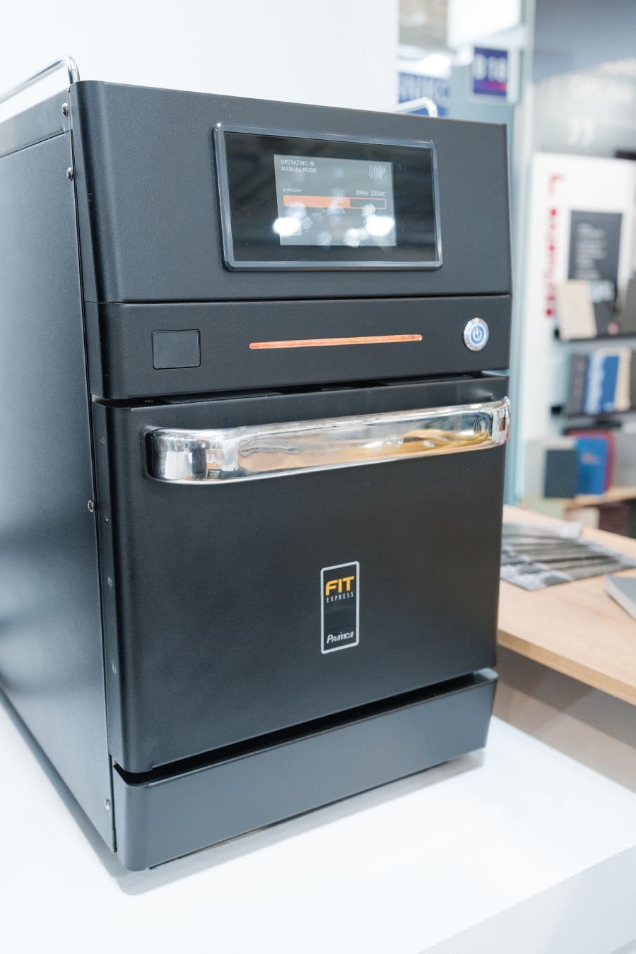 Um forno preto está sobre uma mesa branca.