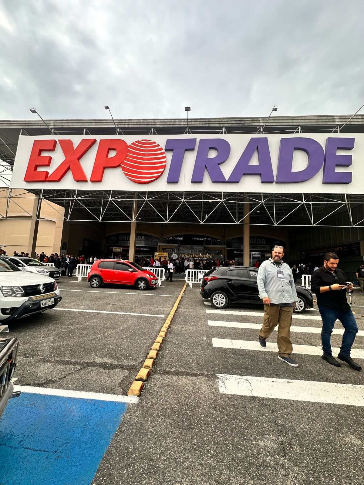 Um grupo de pessoas está em frente a uma grande placa de exportação.