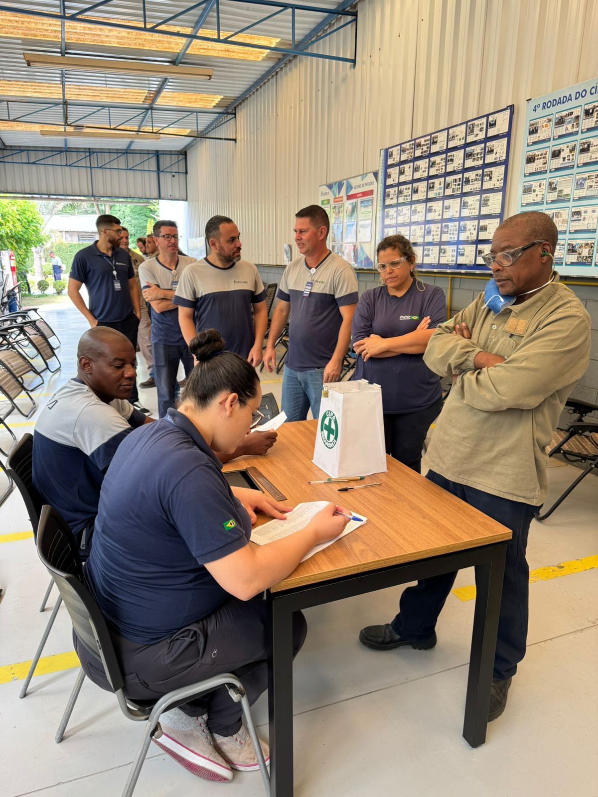 Um grupo de pessoas está sentado à mesa em um armazém.