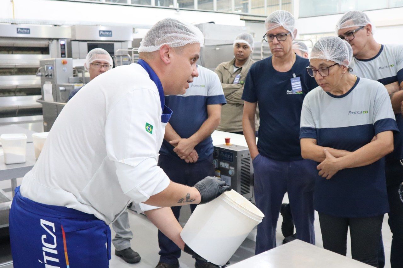 Um homem está segurando um balde na frente de um grupo de pessoas.