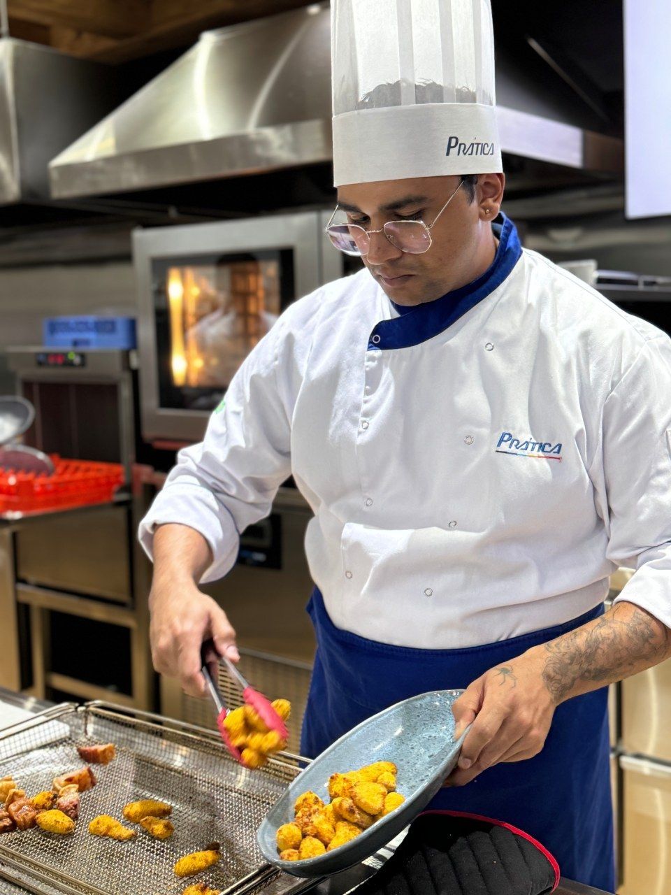 Um chef está cozinhando comida em uma frigideira em uma cozinha.