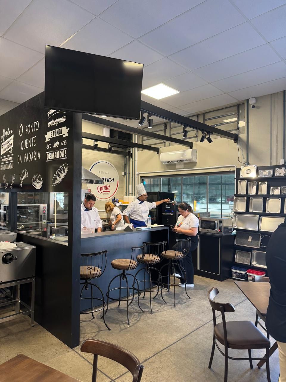 Um grupo de pessoas está em volta de um balcão em um restaurante.