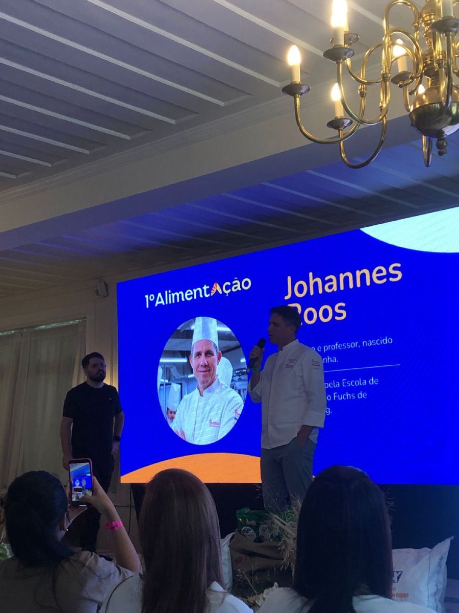 Um homem está em frente a uma tela grande que diz johannes doos