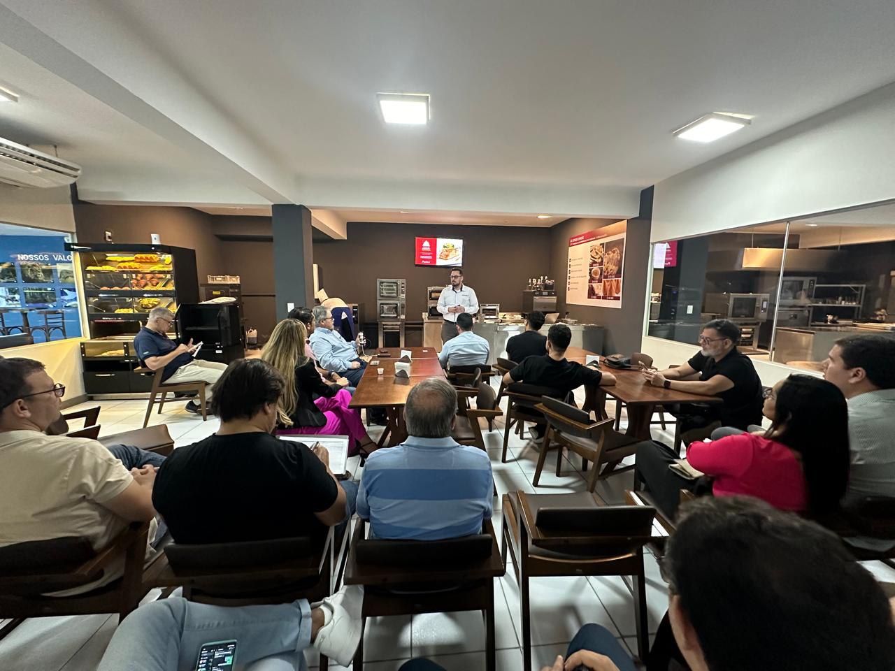 Um grupo de pessoas está sentado em mesas em um restaurante.