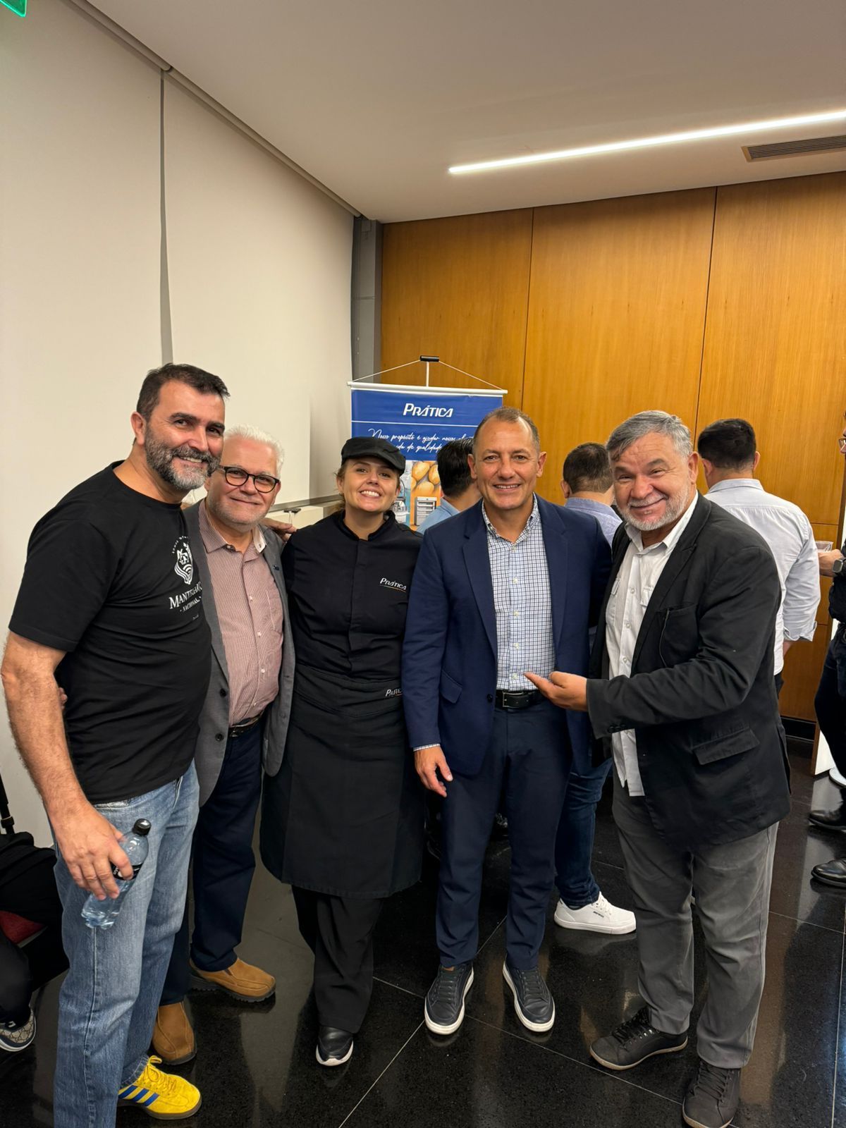 Um grupo de homens está posando para uma foto em uma sala.