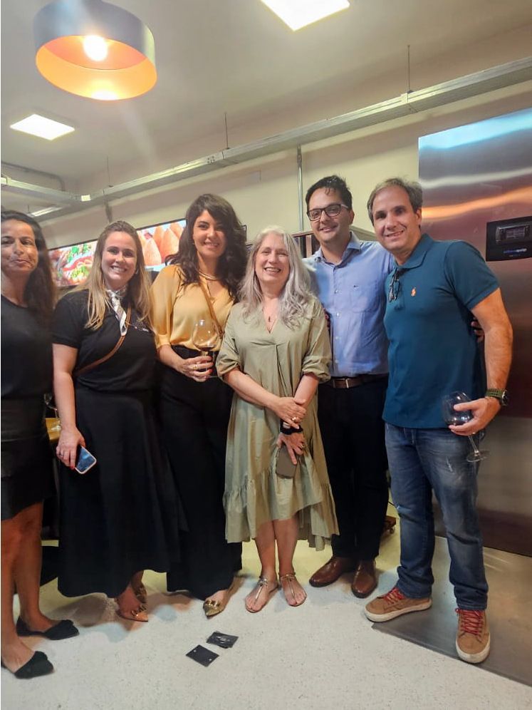 Um grupo de pessoas está posando para uma foto em uma cozinha.