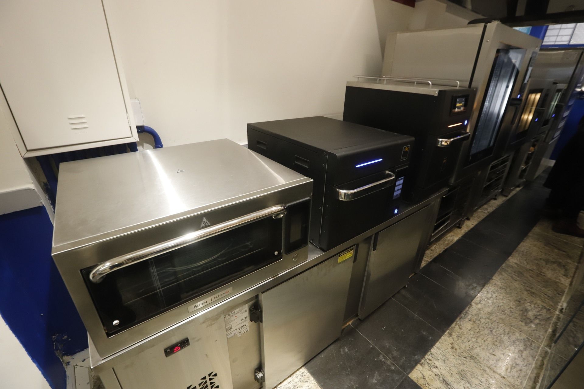 Eletrodomésticos de cozinha comercial, incluindo um forno, empilhados.