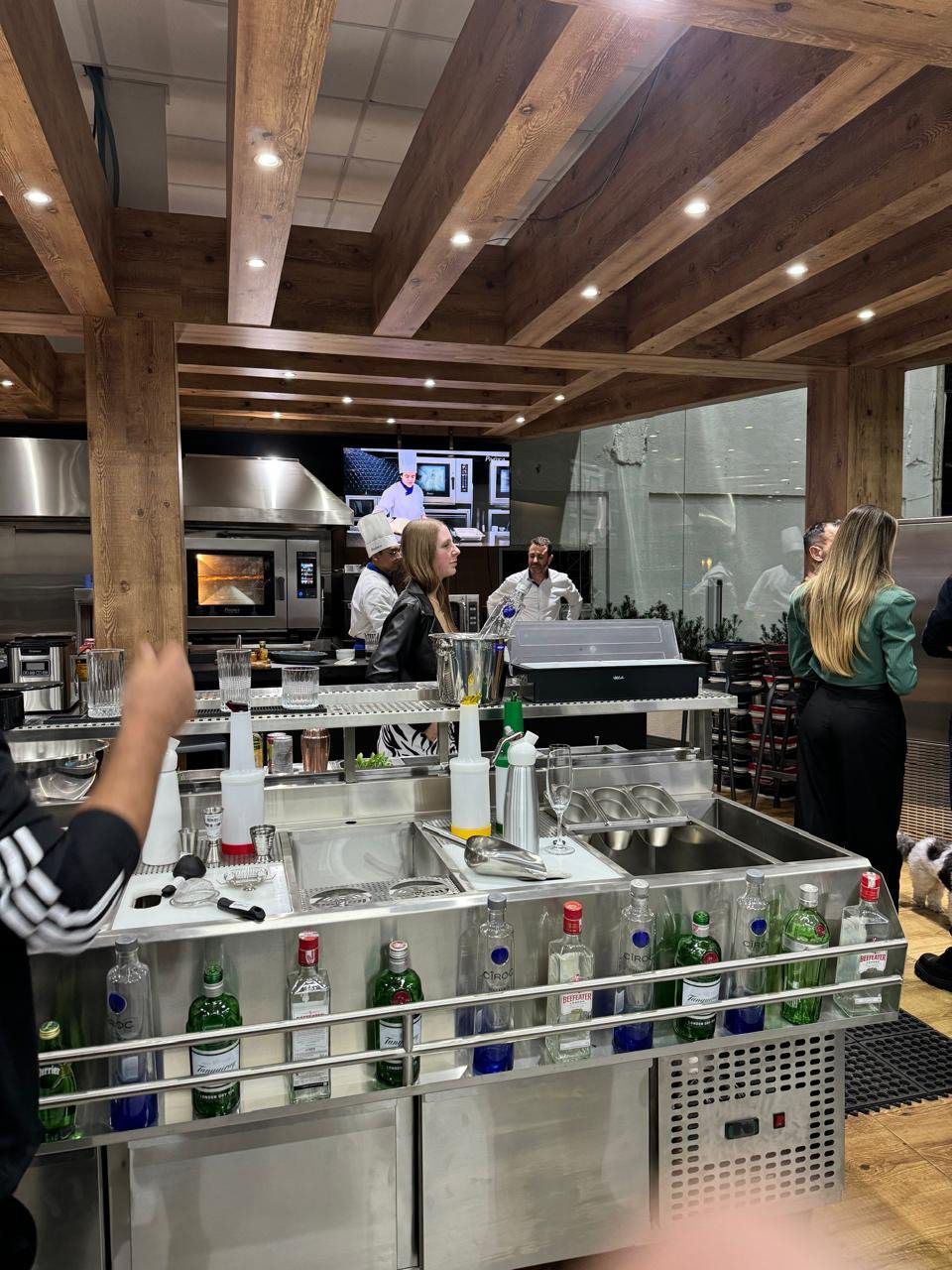 Uma cozinha com muitas garrafas de bebidas no balcão.