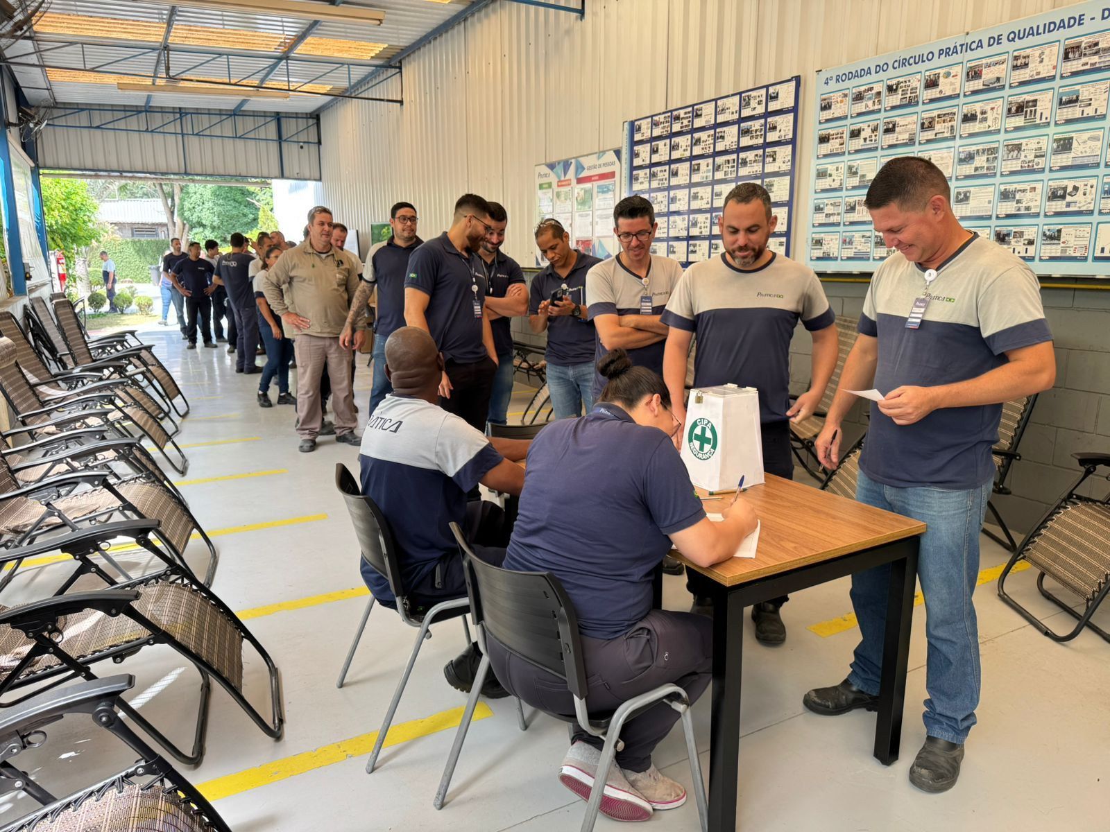 Um grupo de homens está em pé ao redor de uma mesa em uma sala.