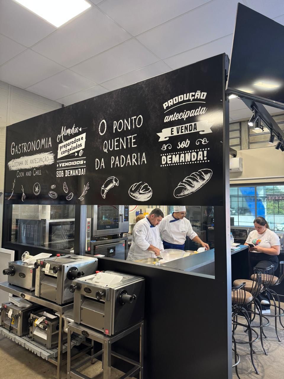 A kitchen with a chalkboard on the wall that says o ponto quente da padaria