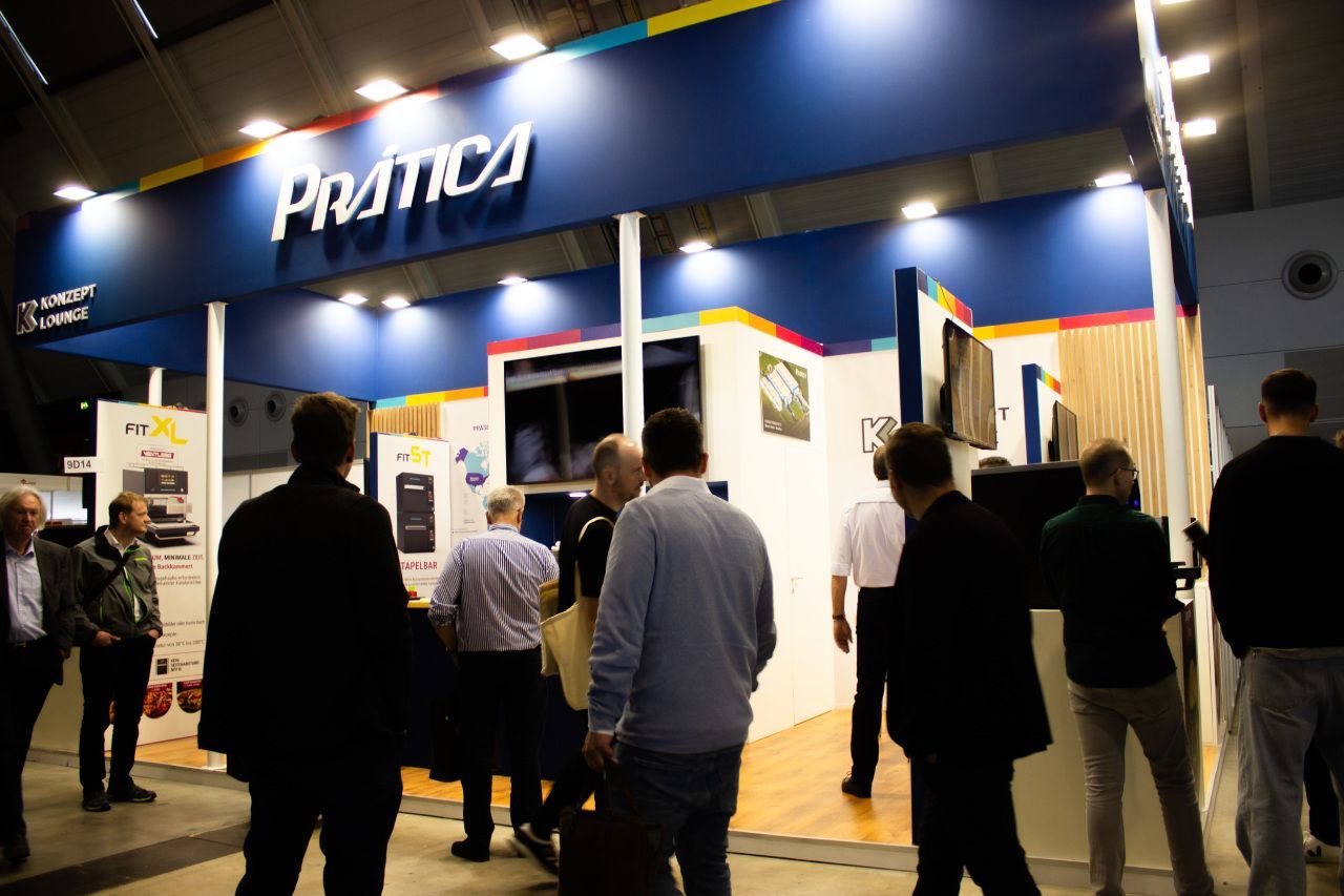 Um grupo de pessoas está em frente a uma cabine de prática