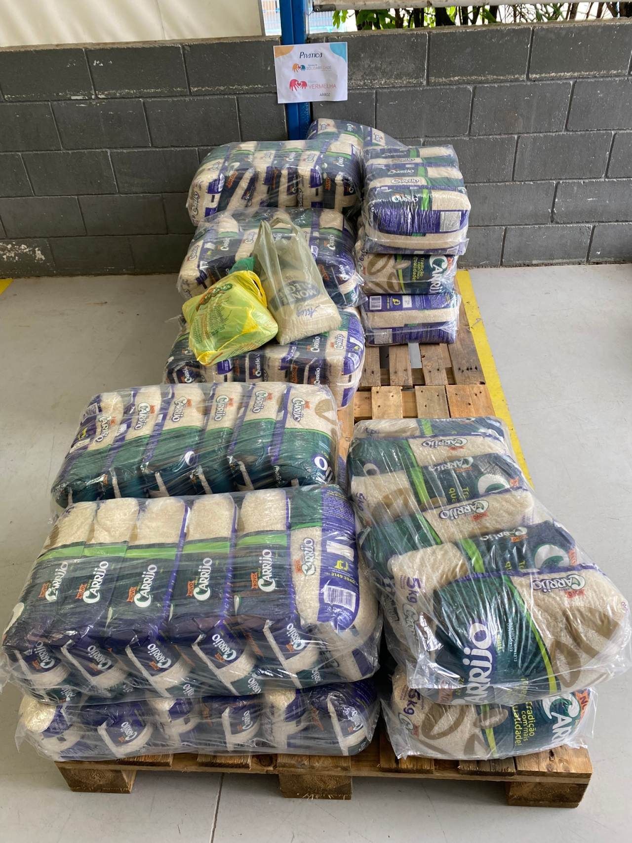 Um palete de madeira cheio de sacos de arroz em um armazém.