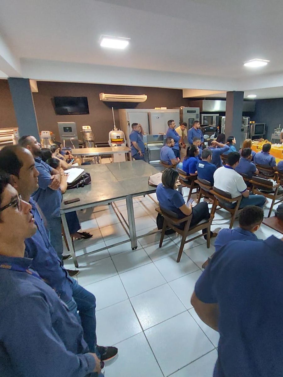 Um grupo de pessoas está sentado em cadeiras em uma sala.