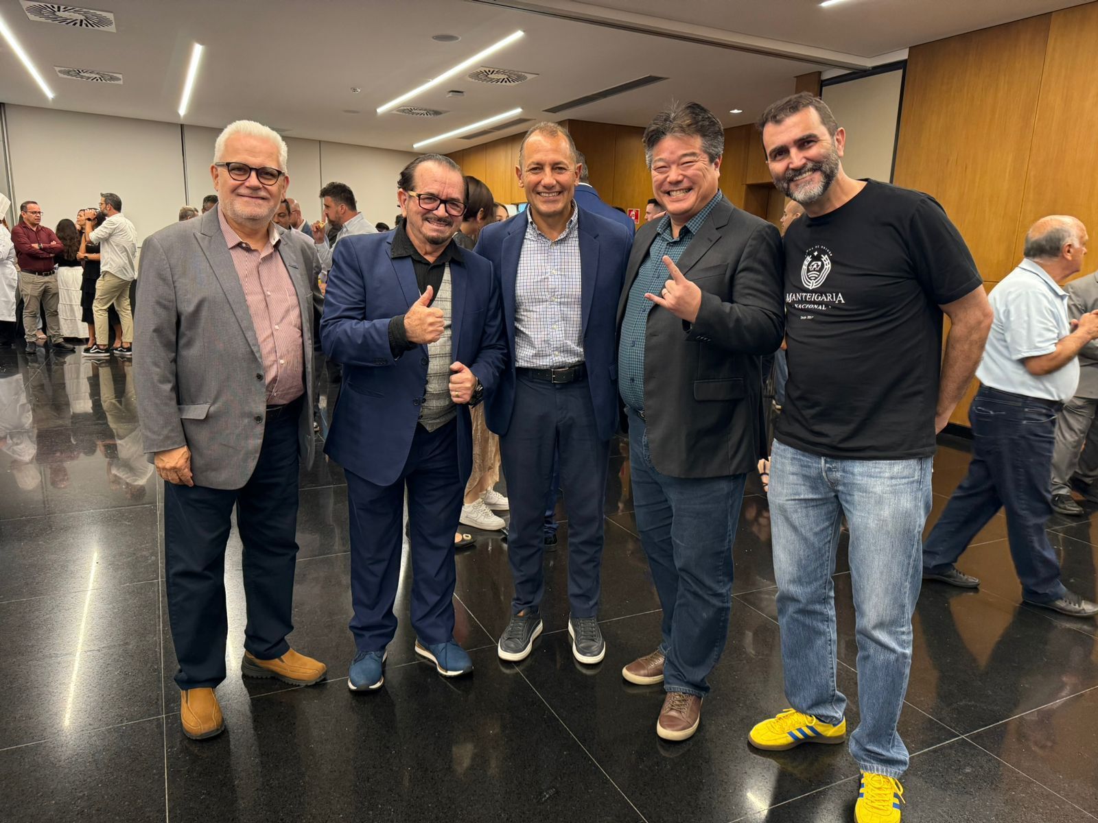 Um grupo de homens está posando para uma foto em uma sala.