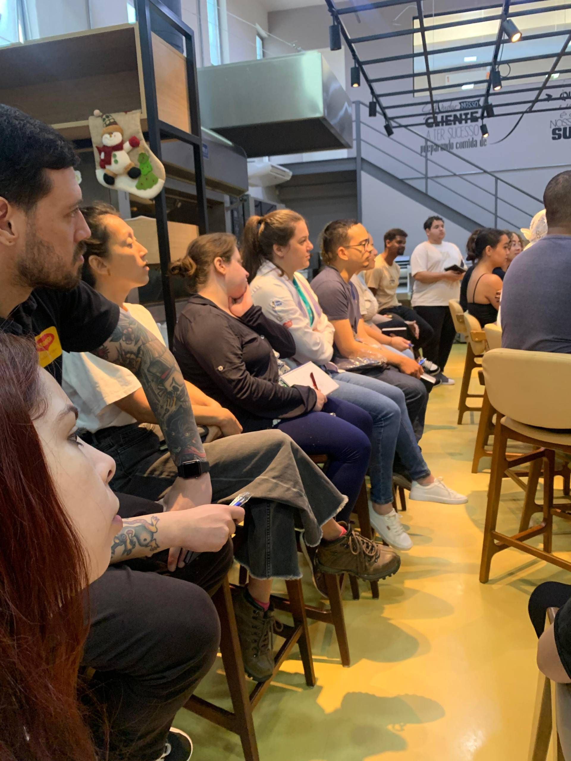 Um grupo de pessoas está sentado em cadeiras em uma sala.