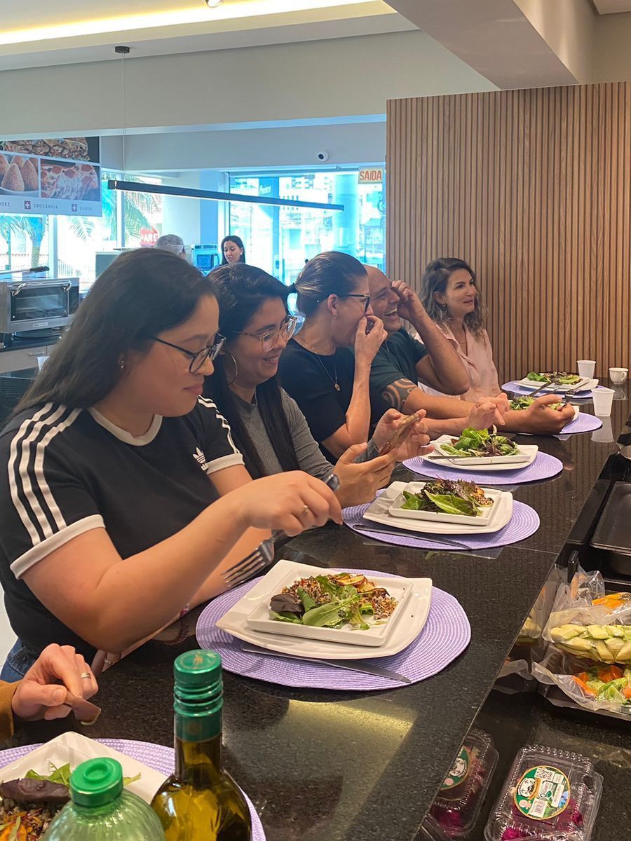 Um grupo de pessoas está sentado à mesa comendo.
