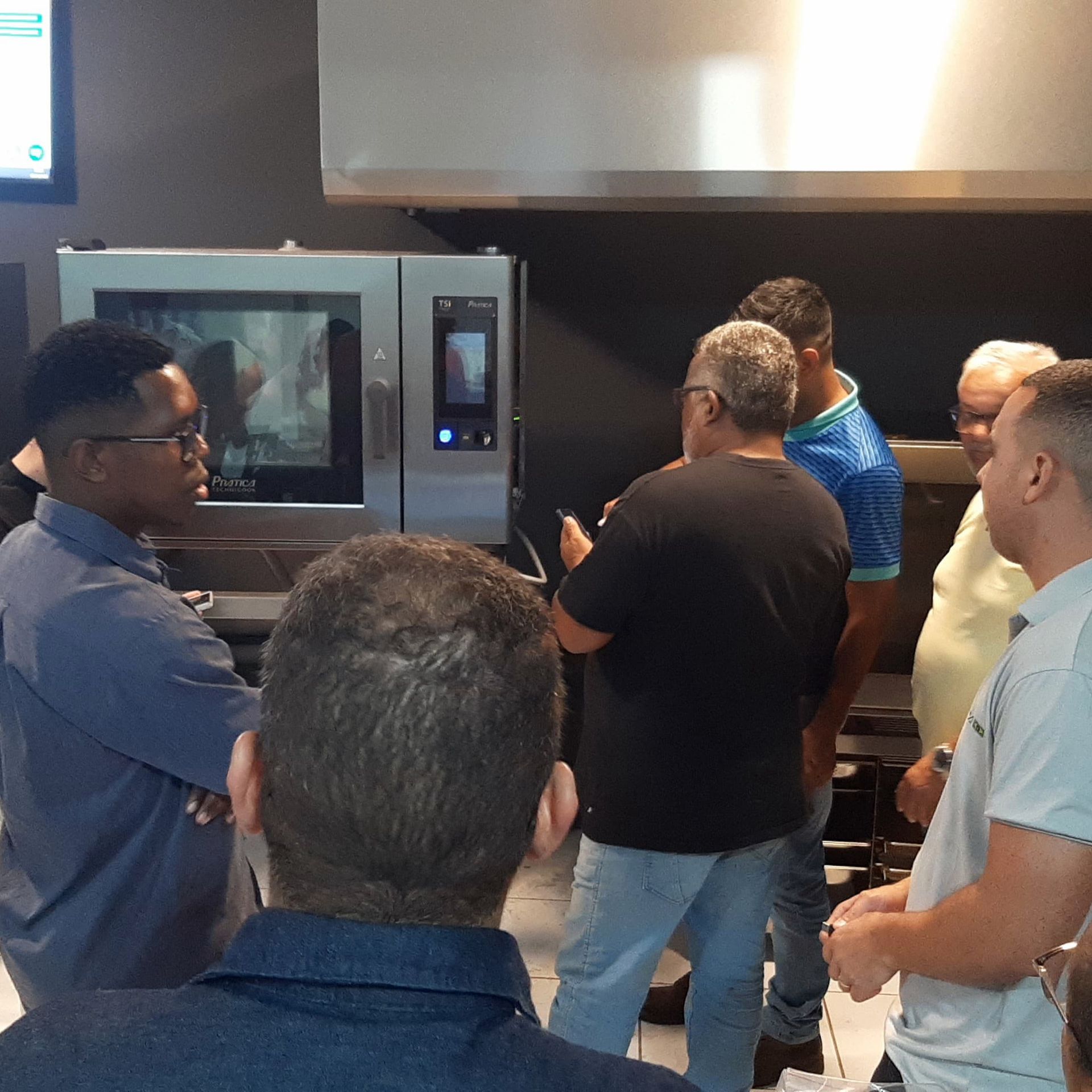 Um grupo de homens está em frente a um micro-ondas