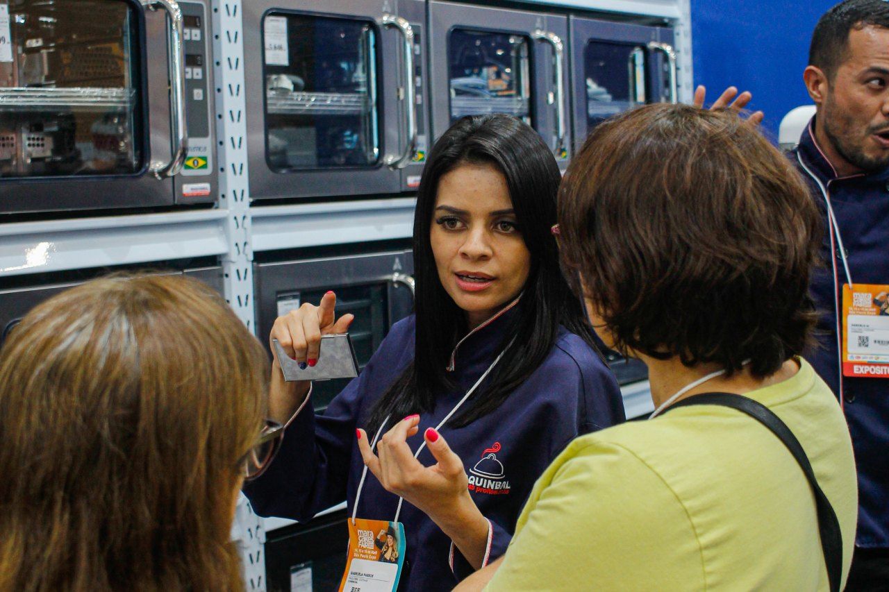 Uma mulher está conversando com um grupo de pessoas em uma loja.