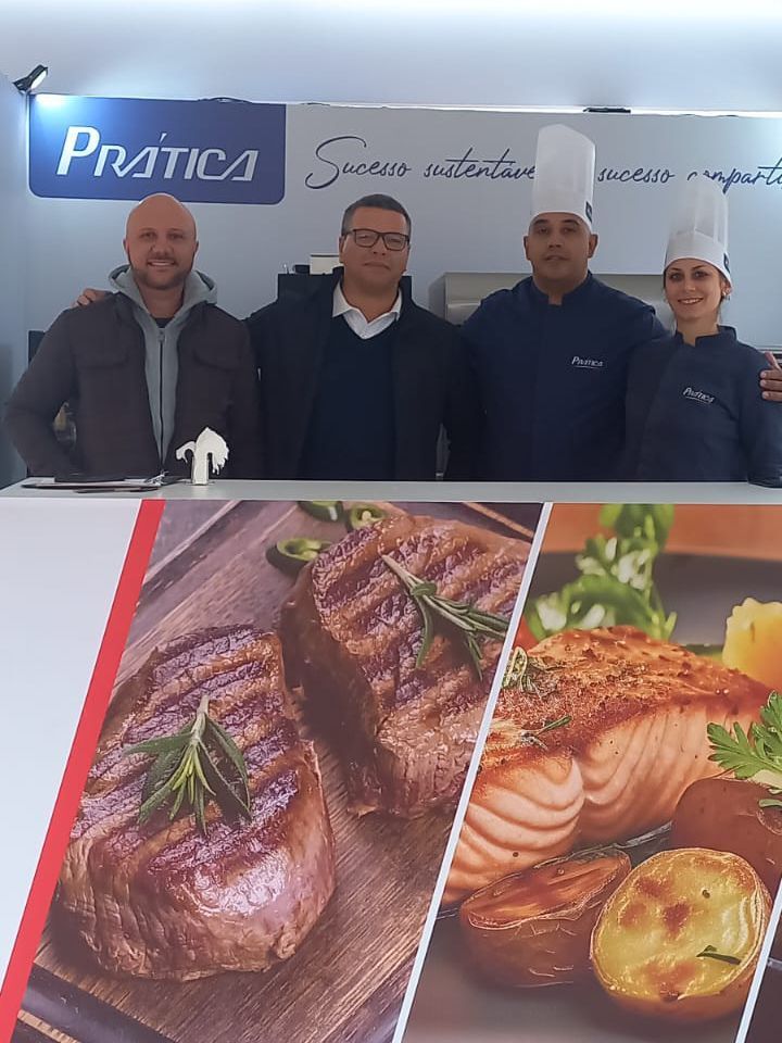 Um grupo de pessoas está em frente a uma placa que diz pratica