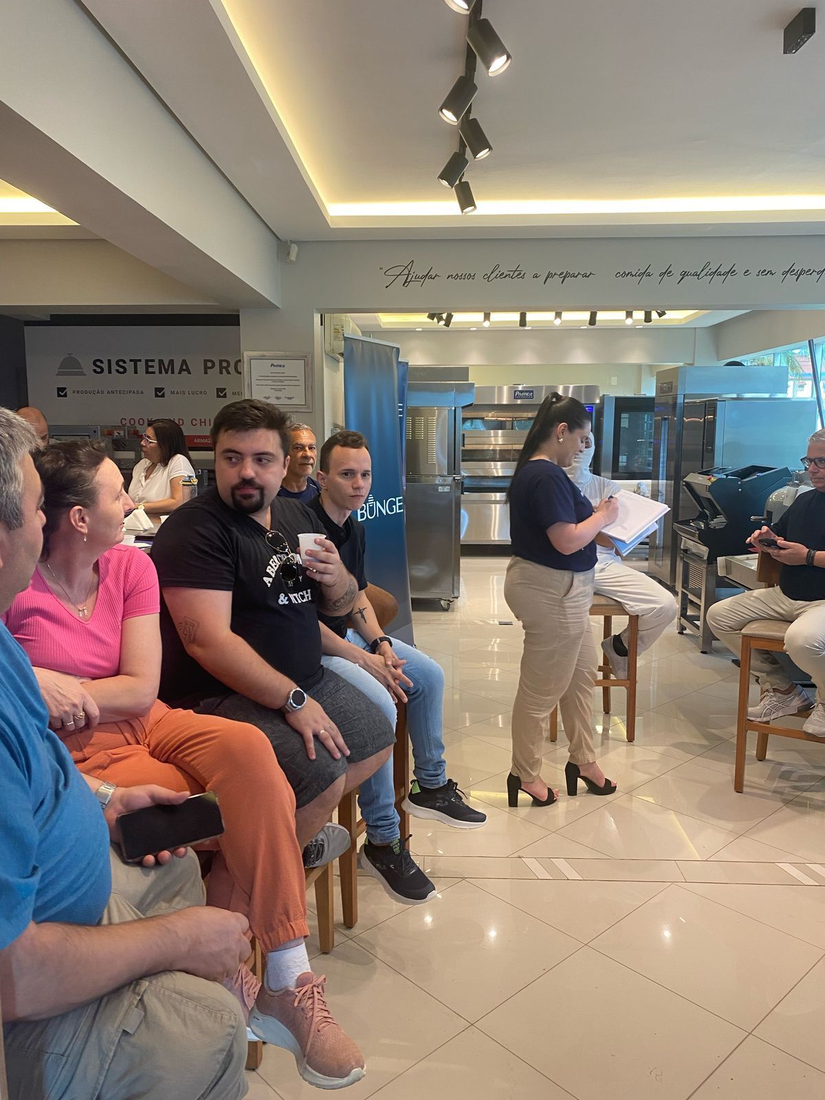 Um grupo de pessoas está sentado em cadeiras em um restaurante.