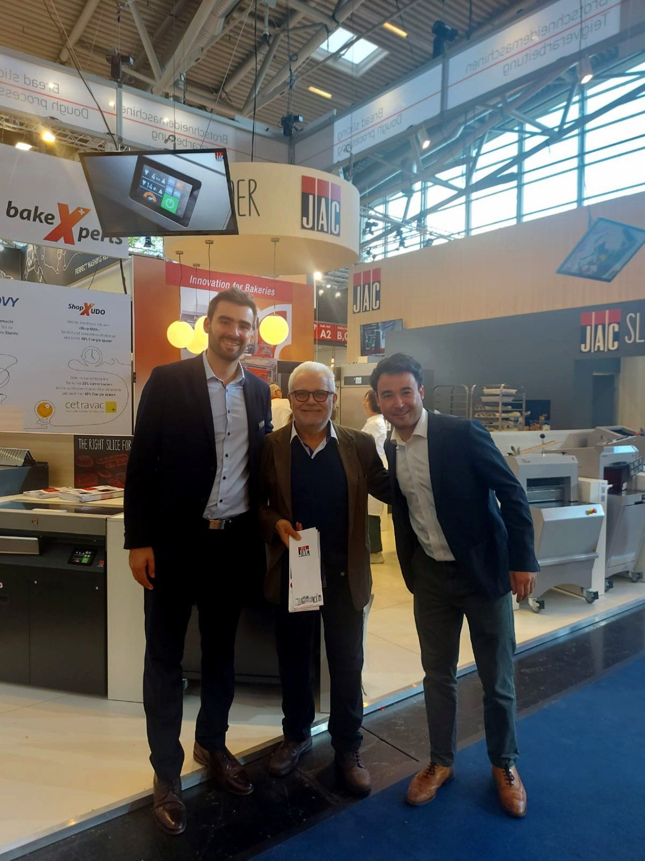 Três homens estão posando para uma foto em uma convenção