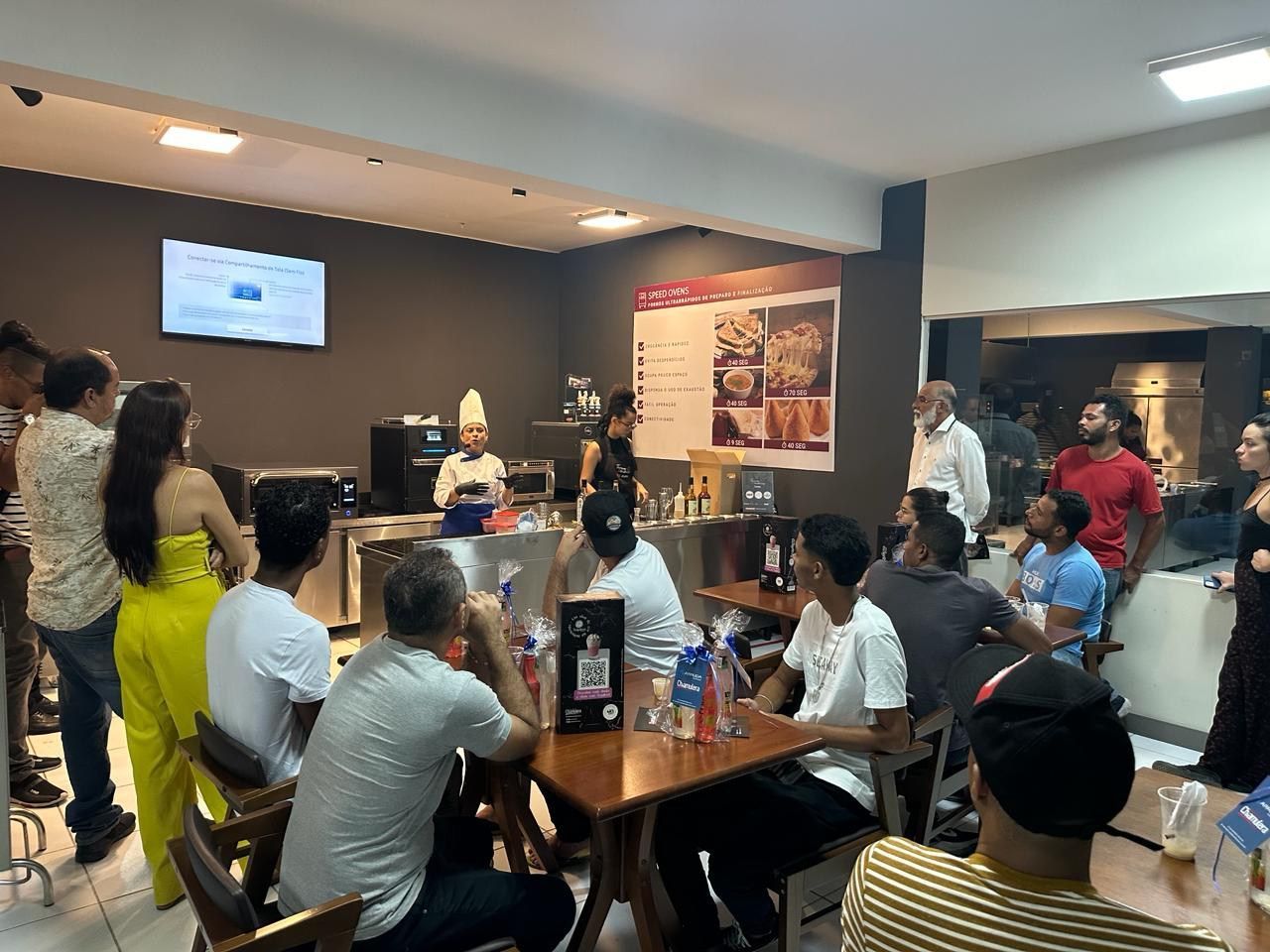 Um grupo de pessoas está sentado em mesas em um restaurante.