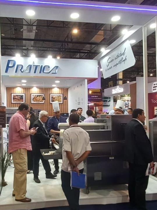 Um grupo de pessoas em pé na frente de um estande de prática