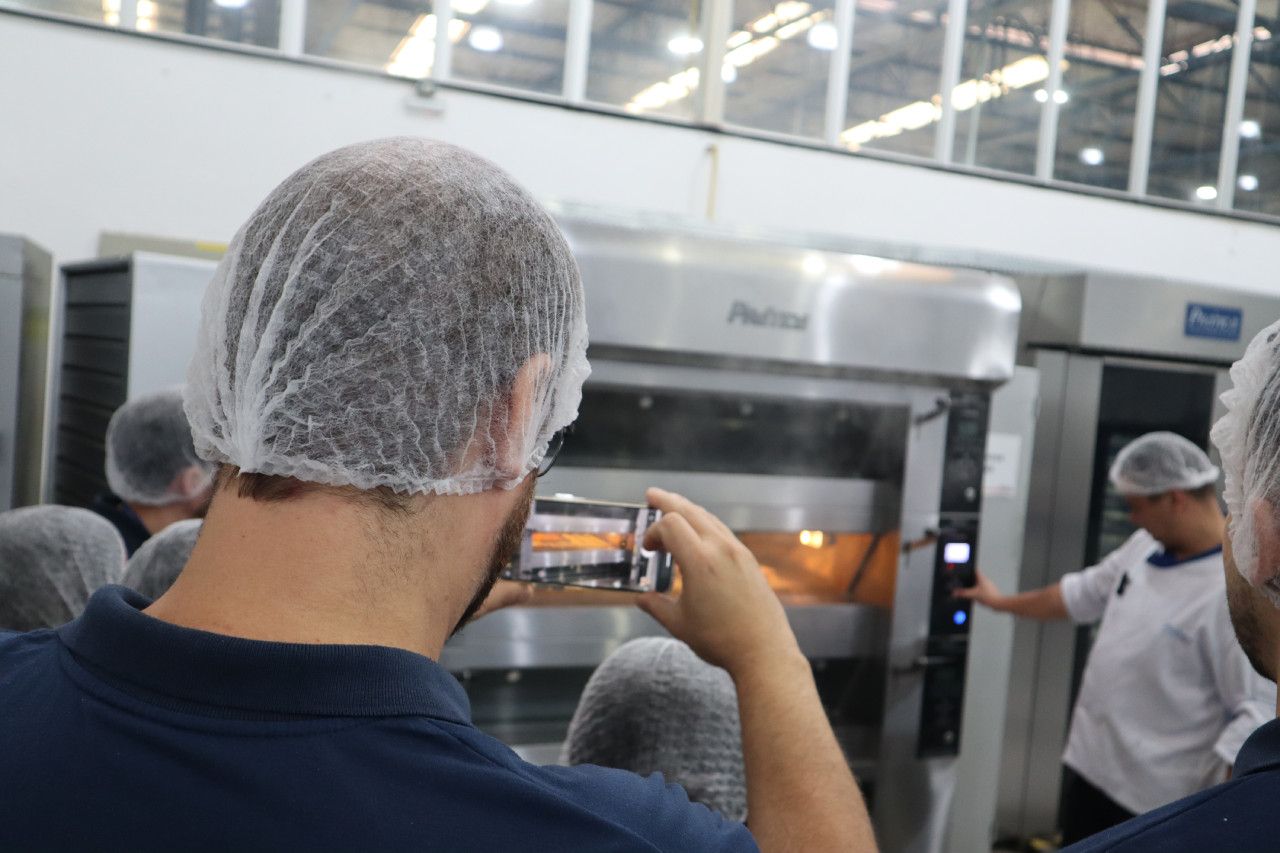 Um homem está tirando uma foto de um forno com seu telefone