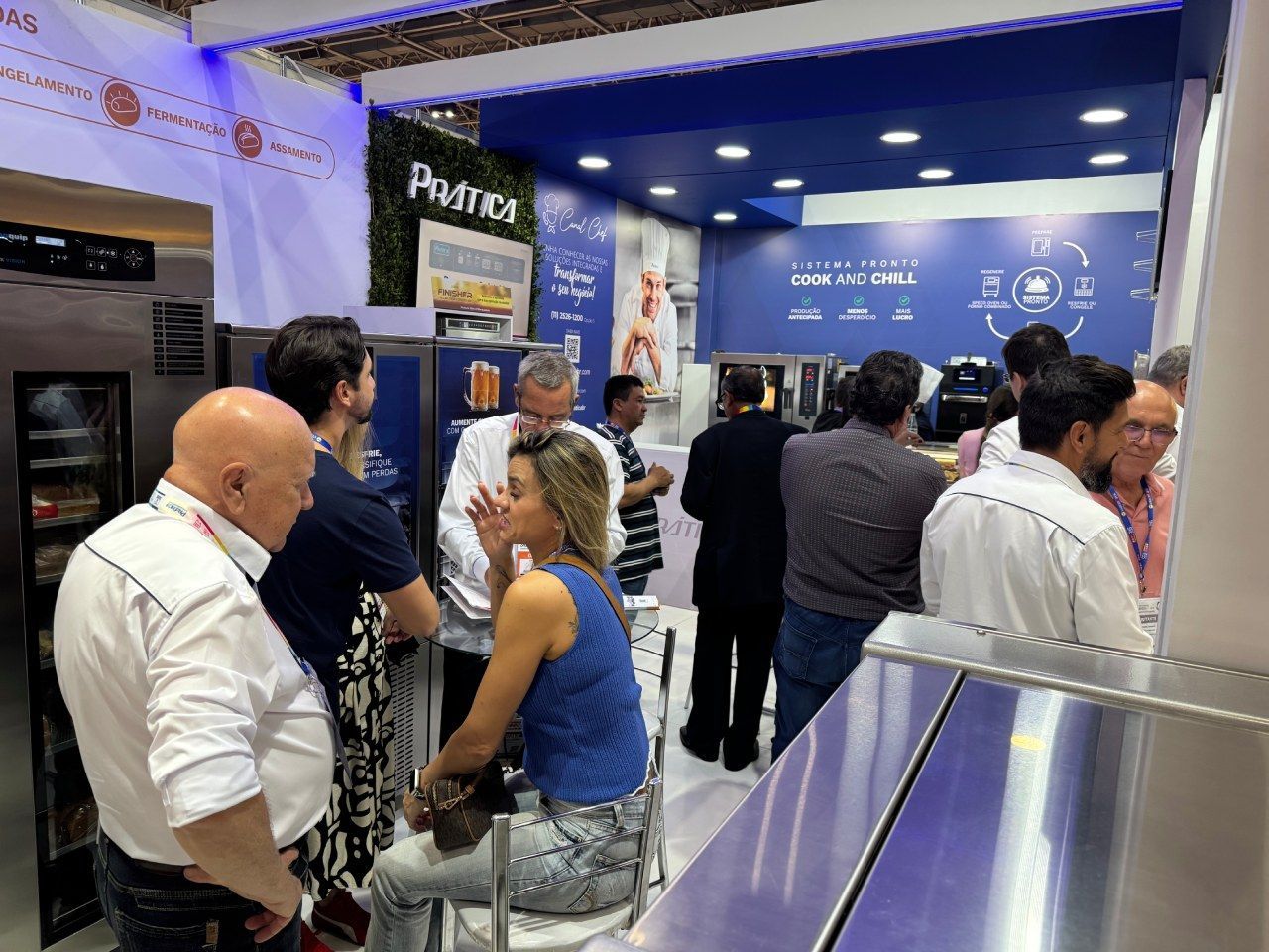 Um grupo de pessoas está em volta de um balcão em um restaurante.