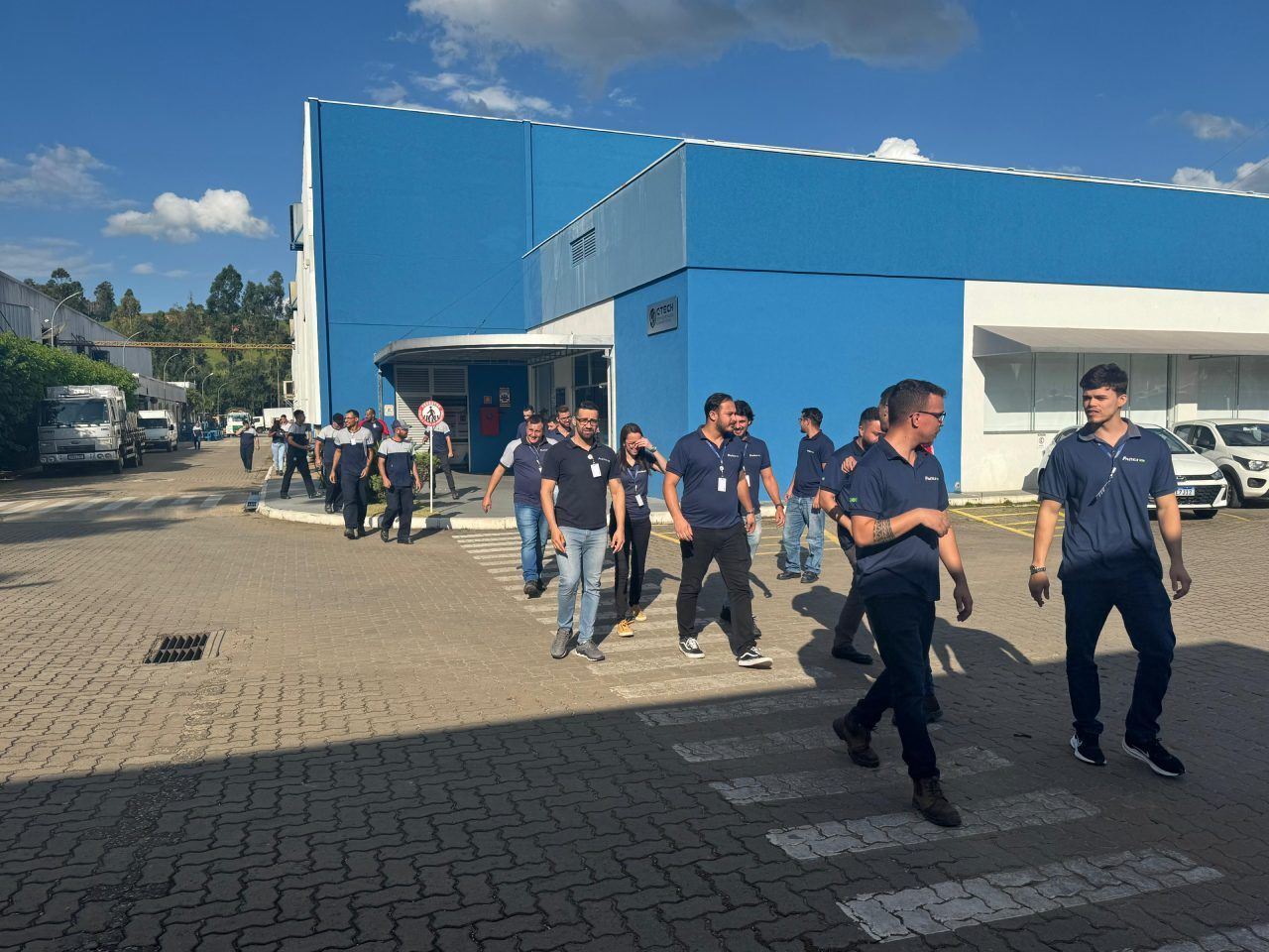 Um grupo de pessoas está caminhando em frente a um prédio azul.