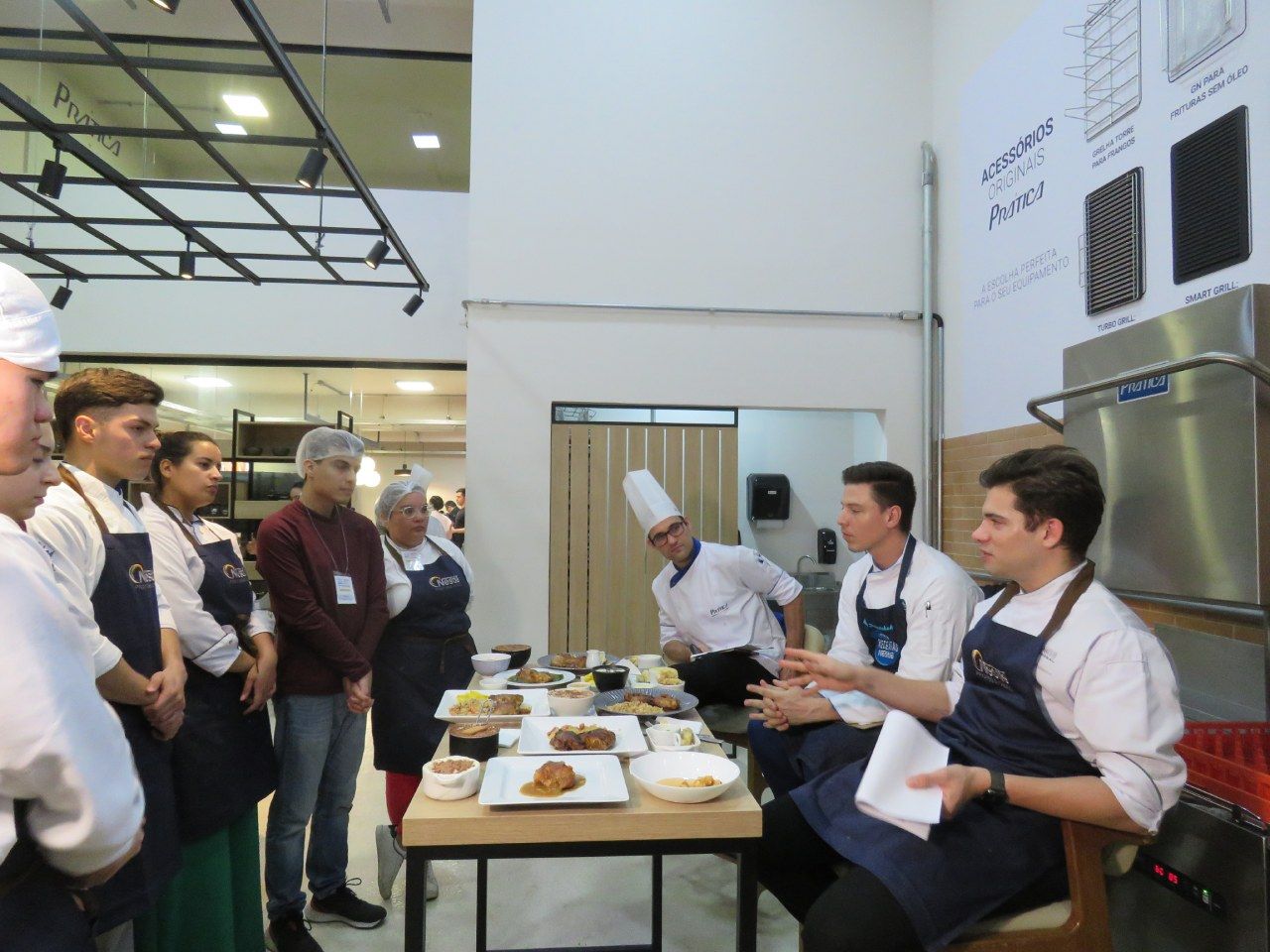 Um grupo de pessoas em pé ao redor de uma mesa com pratos de comida sobre ela