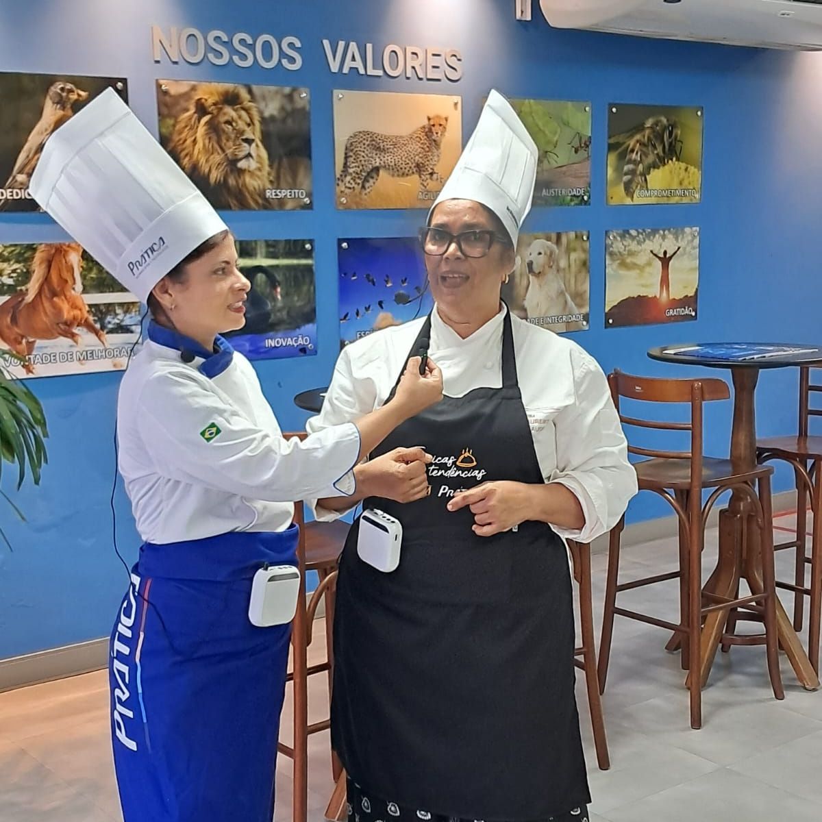 Duas mulheres estão em pé em frente a uma parede que diz nossos valores