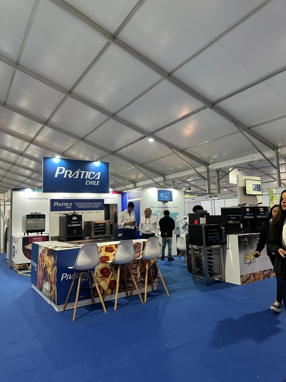 Pessoas em pé em uma sala com uma placa que diz pratica