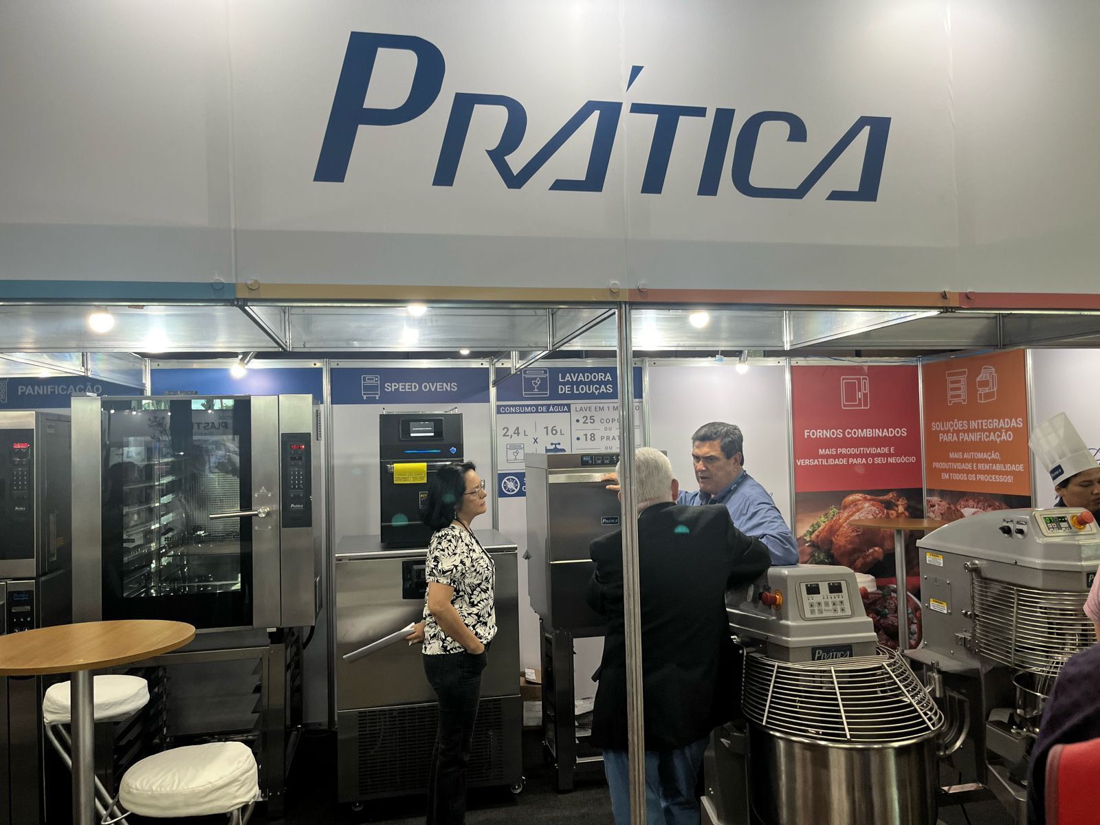 Um grupo de pessoas em pé na frente de um estande de prática