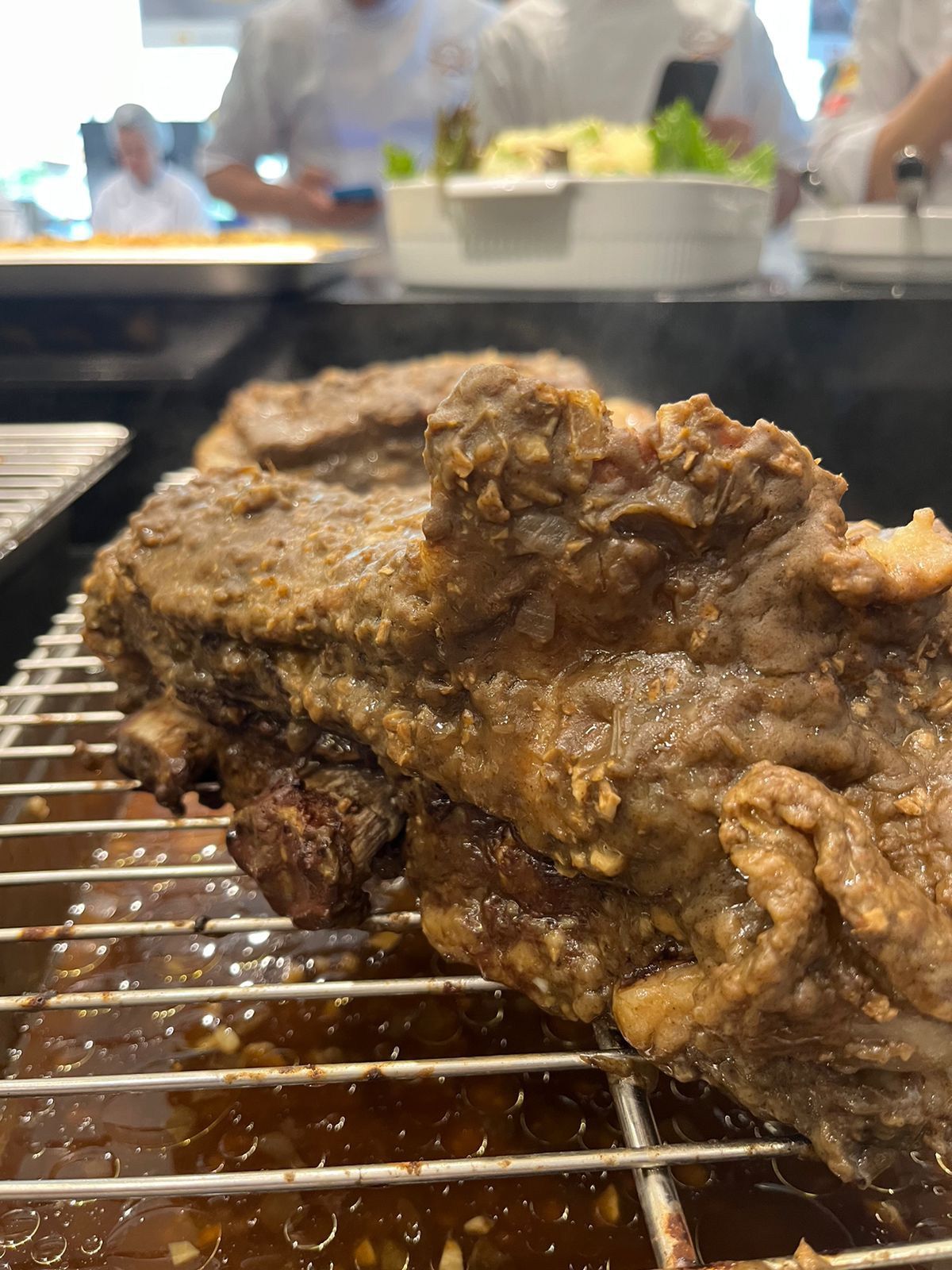 Um grande pedaço de carne está cozinhando na grelha.
