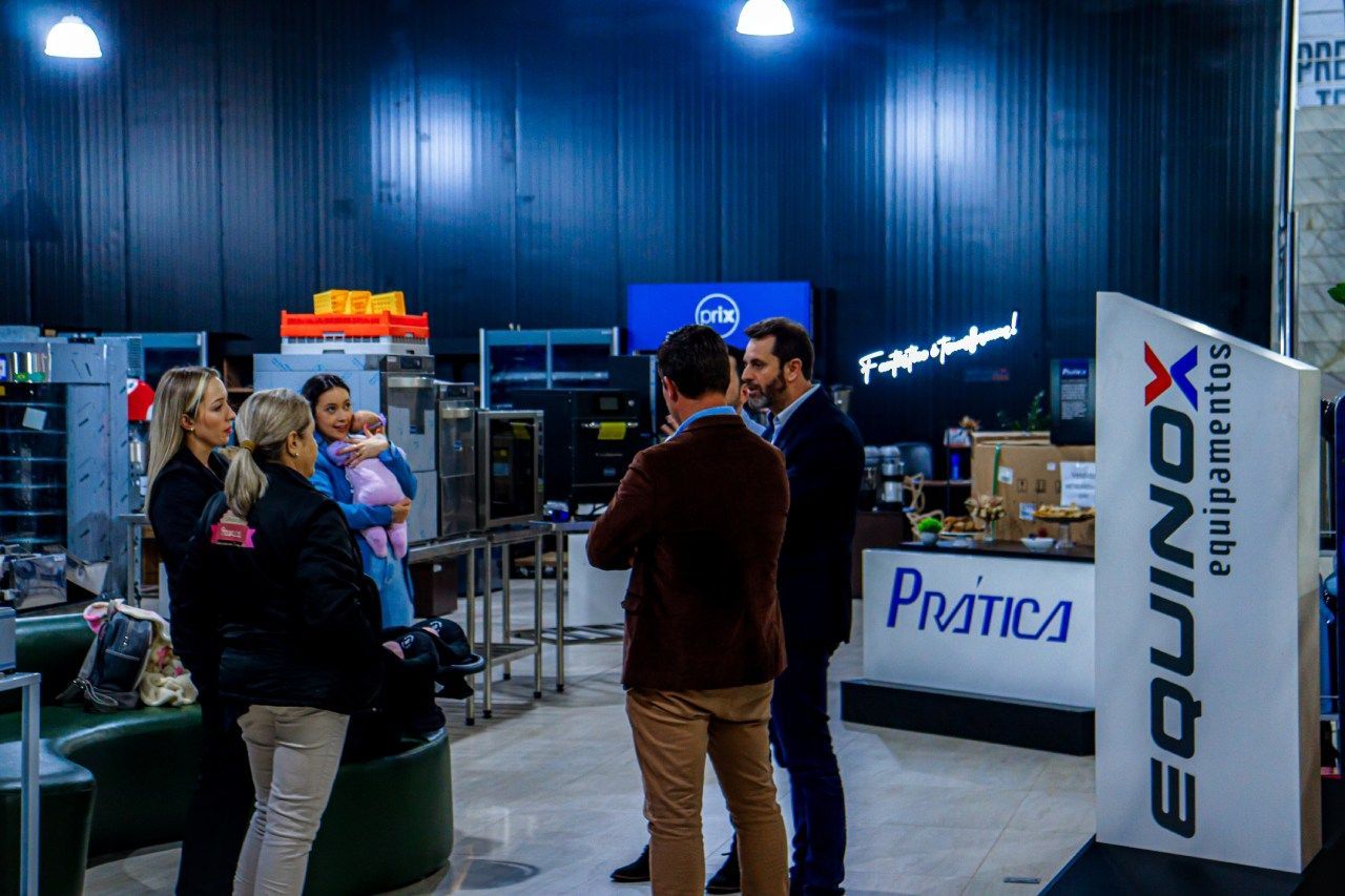 Um grupo de pessoas está em pé ao redor de um balcão em uma loja.