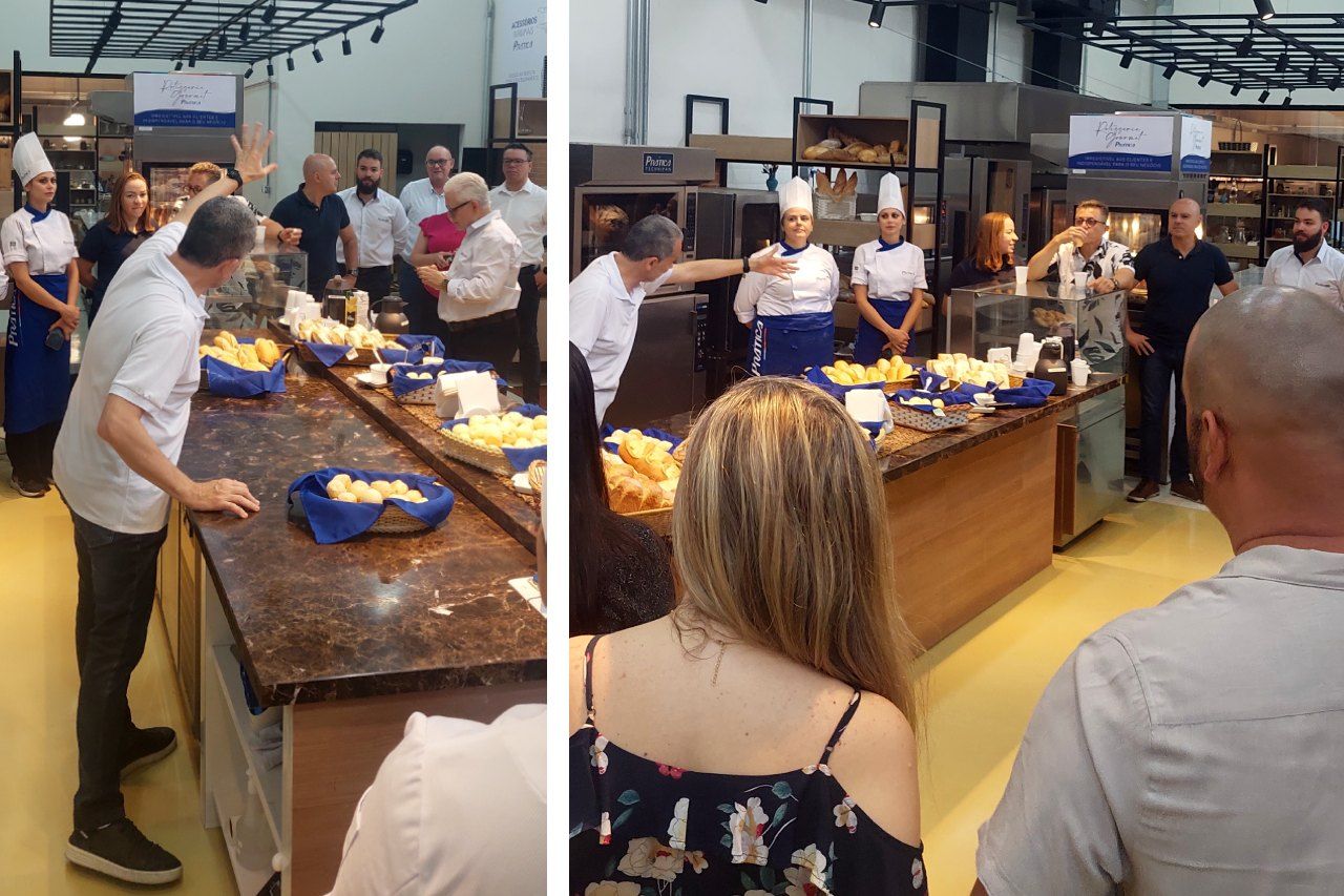 Um grupo de pessoas está em pé ao redor de uma mesa na cozinha.
