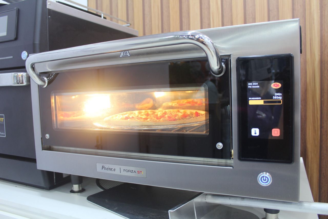 Uma pizza está sendo cozida no forno sobre uma mesa.