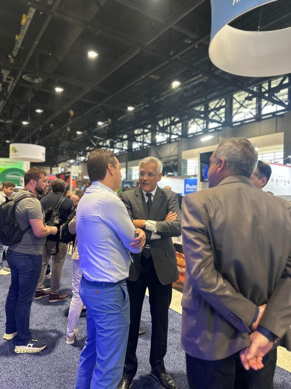 Um grupo de homens está em uma sala conversando entre si.