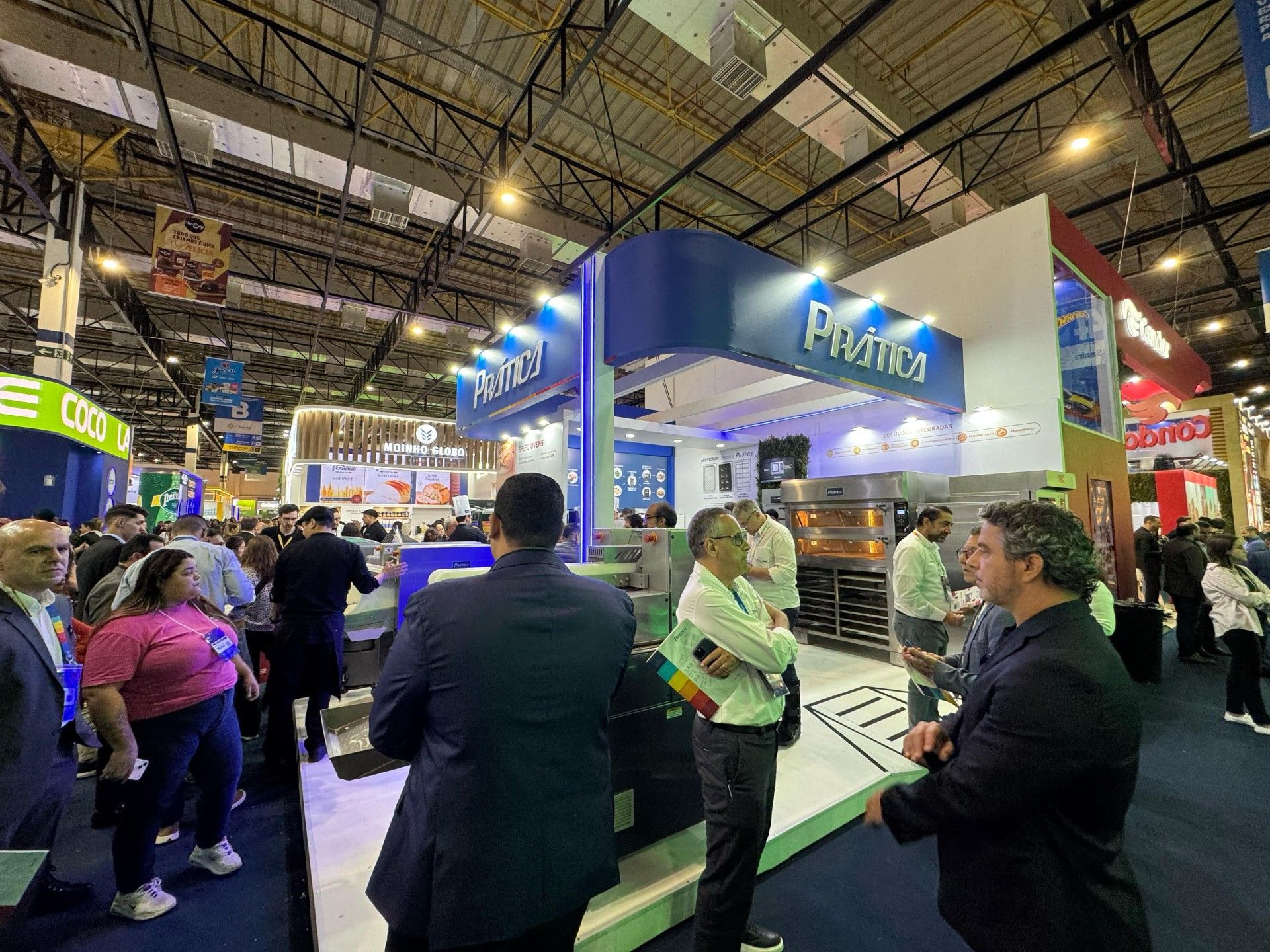 Um grupo de pessoas está em volta de um estande em uma convenção.