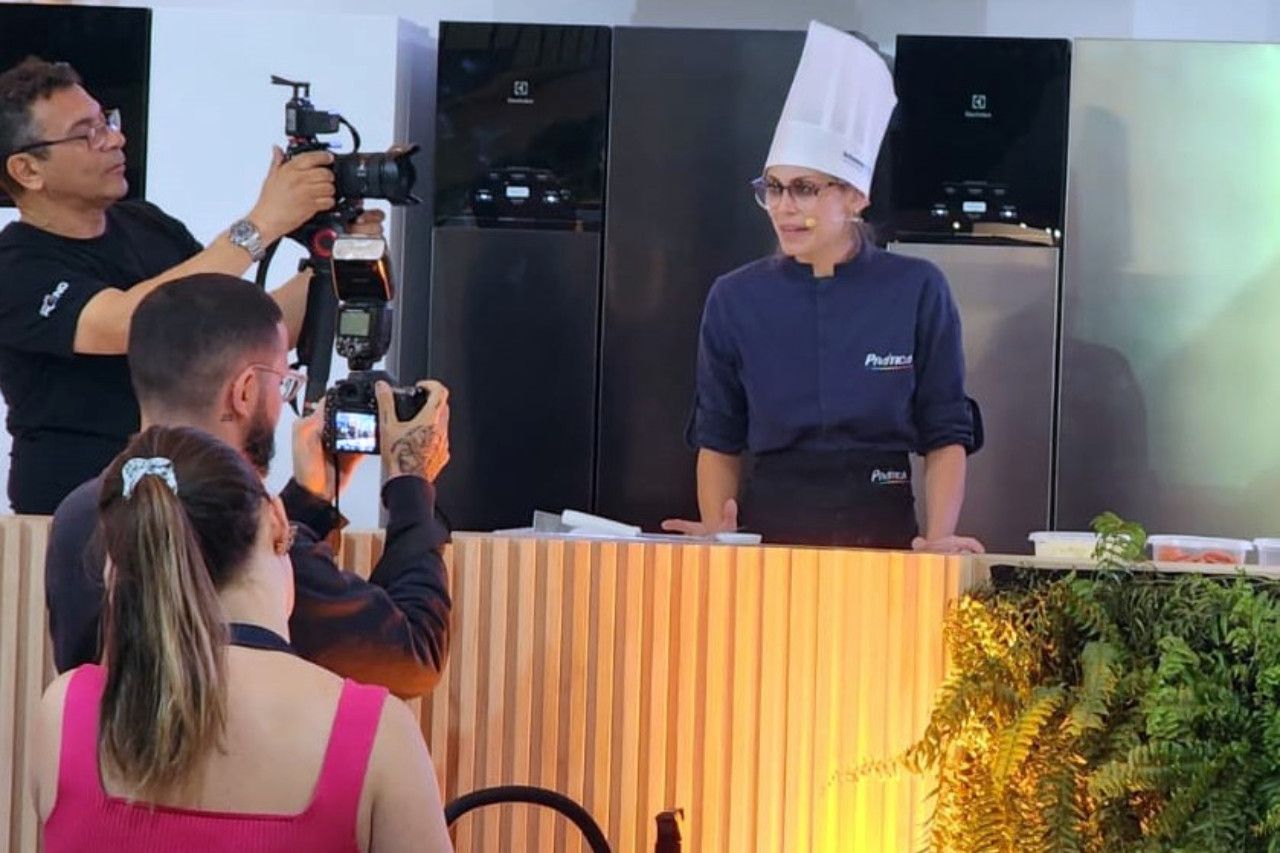 Um homem está tirando uma foto de um chef na frente de uma câmera.