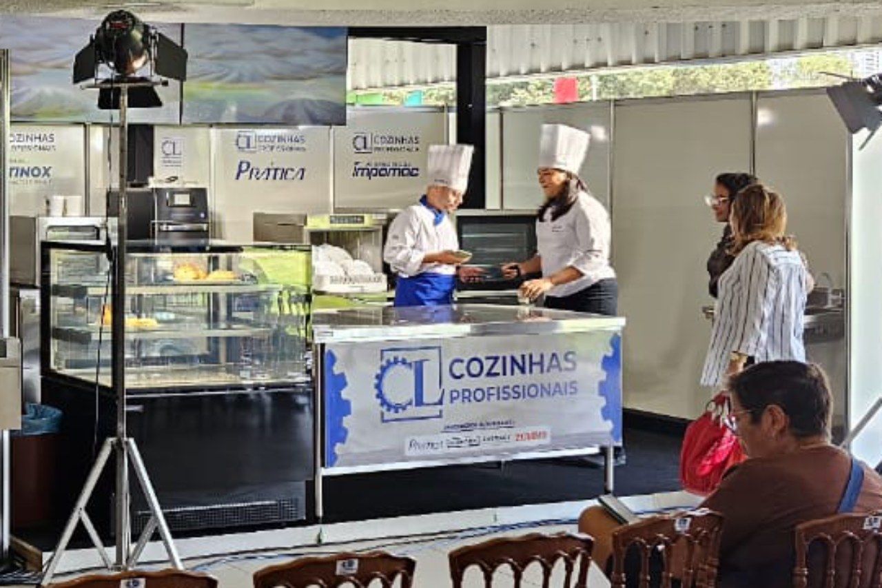 Um grupo de pessoas está sentado em uma mesa em frente a uma placa que diz cozinhas profissionais.