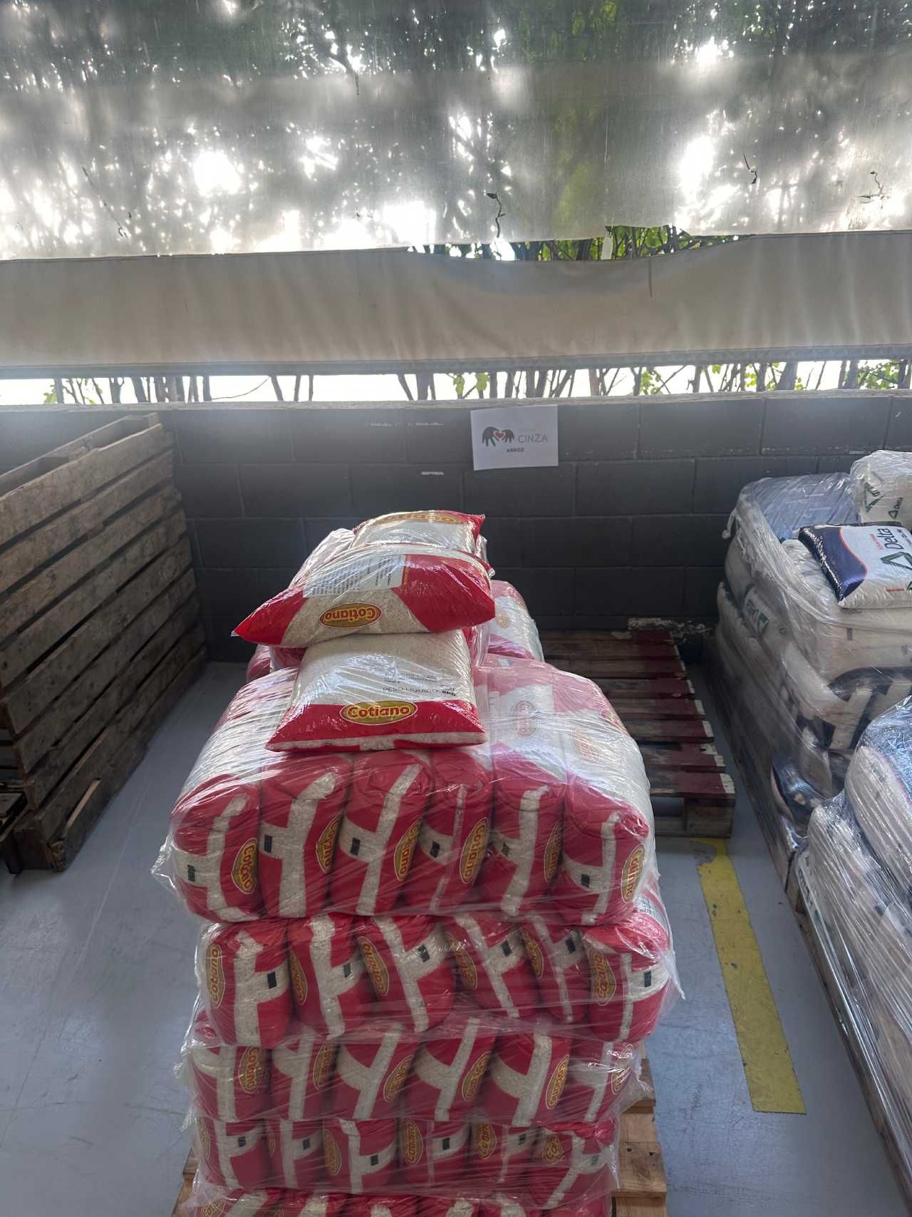 Vários sacos de arroz empilhados uns sobre os outros em um palete.