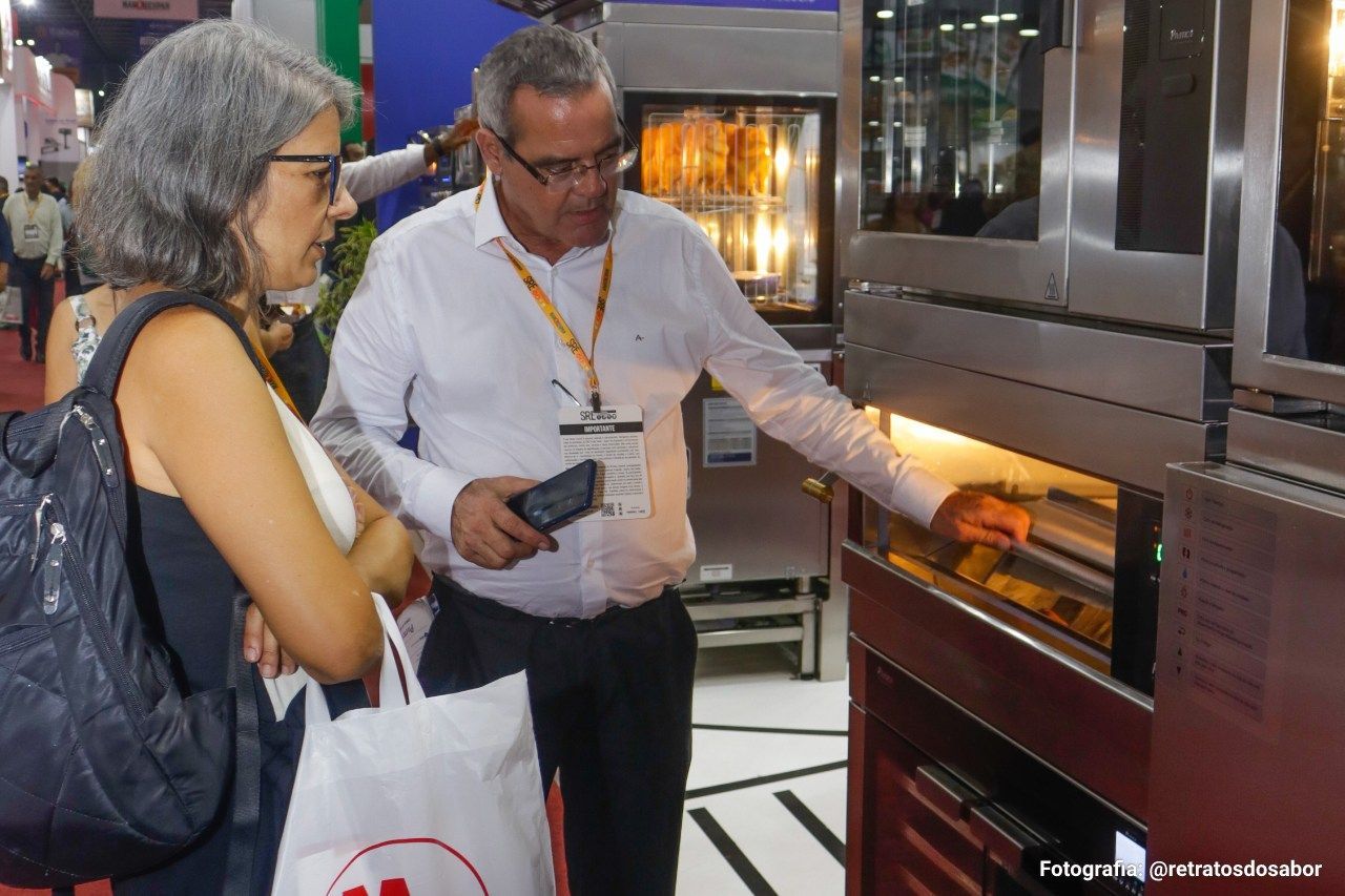 Um homem e uma mulher estão olhando para um forno.