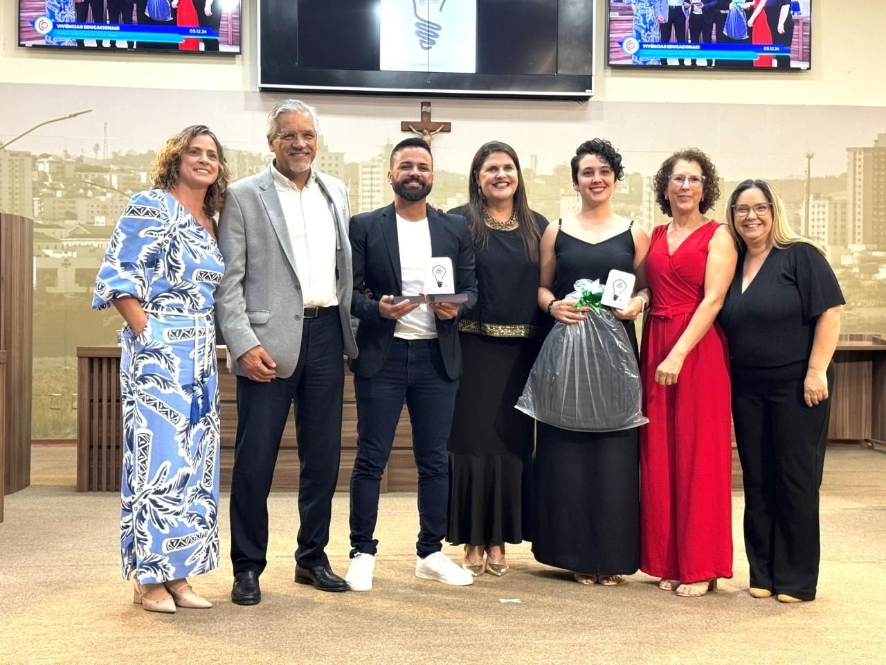 Um grupo de pessoas está posando para uma foto em uma sala.