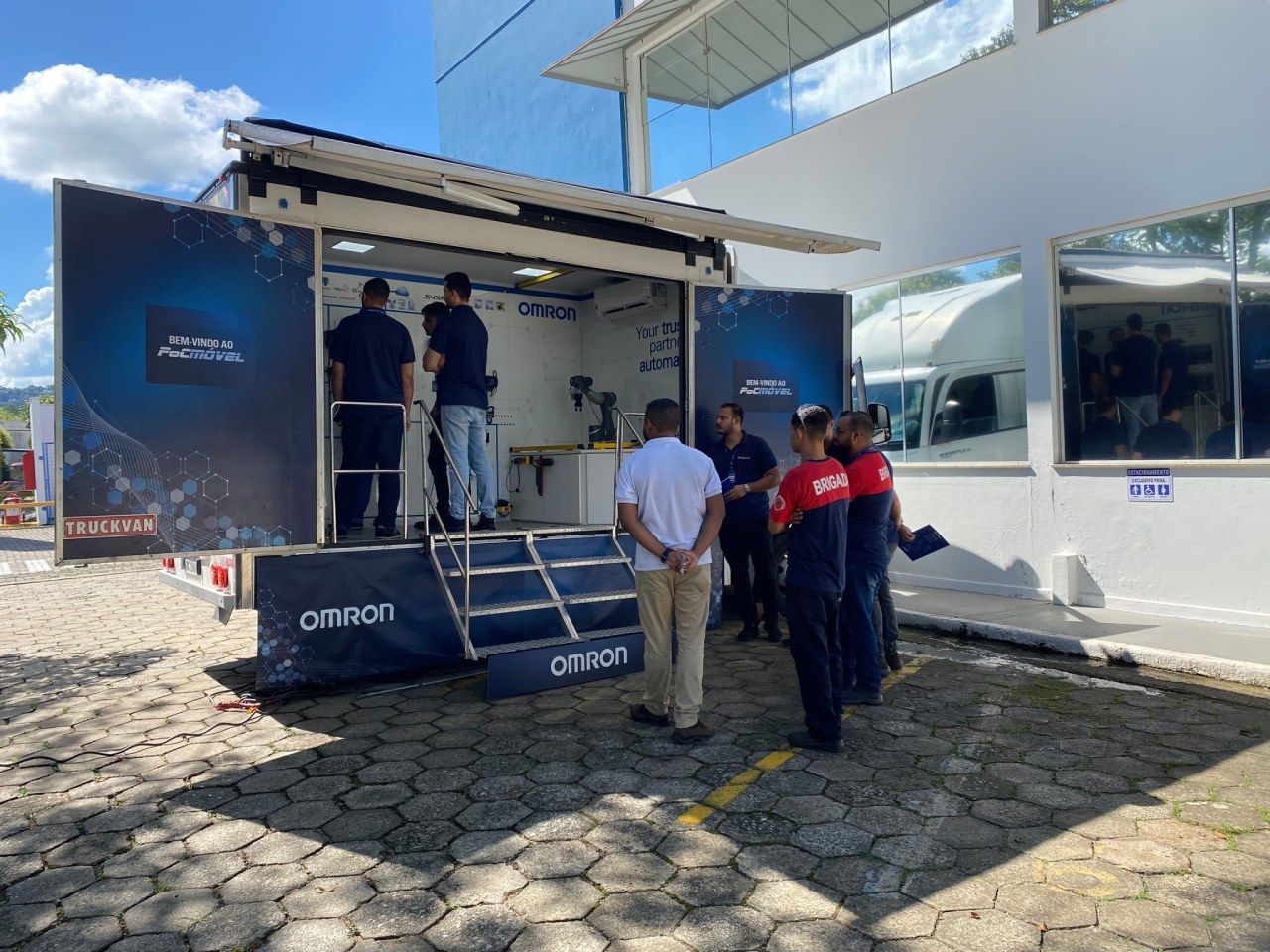 Um grupo de pessoas está em frente a um trailer.