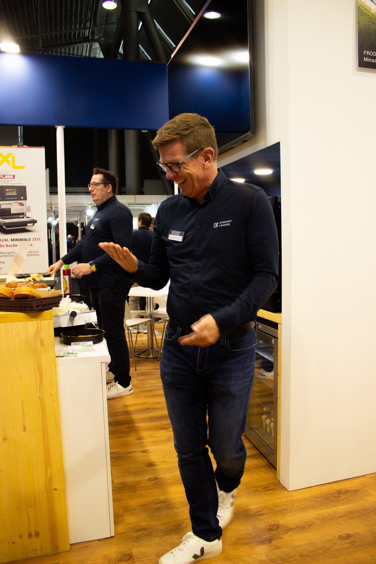 Um homem está em pé em uma sala falando ao celular.