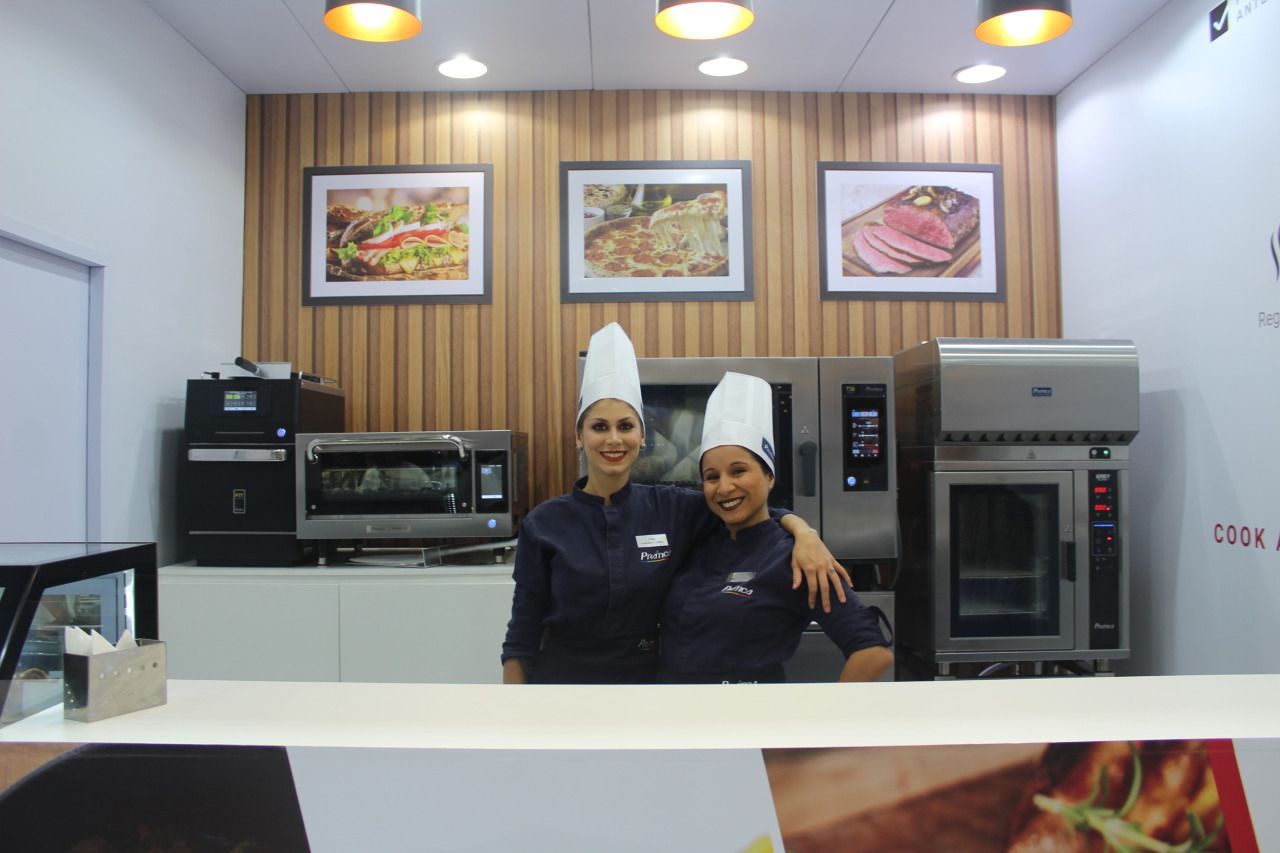 Duas chefs posam para uma foto em uma cozinha