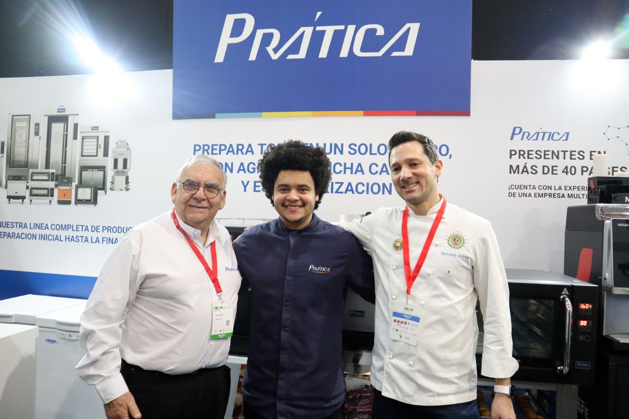 Três homens estão posando para uma foto em frente a uma placa de prática.