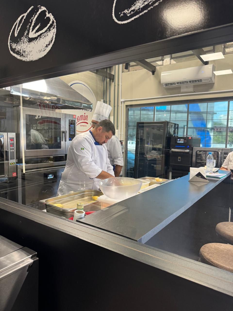 Um homem com uniforme de chef está preparando comida em uma cozinha.